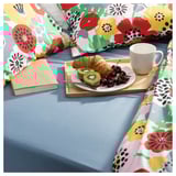 Colorful floral printed bedding set with breakfast tray and book on blue bed