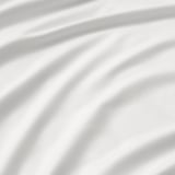 Close-up of smooth, high-quality fabric with intricate texture and subtle sheen, representing luxury.