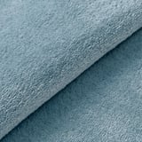 Soft, overlapping rugs in light blue shades, showcasing plush texture and high-quality material.