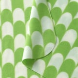 Soft, folded green and white patterned throw blanket; inviting and cozy.