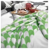 Modern green & white throw blanket on bed - 34 characters