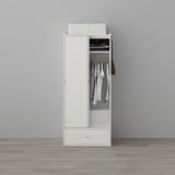 White wardrobe with sliding doors, clothes rail, shelf, and drawer. Holds garments and small items, with hooks on side.