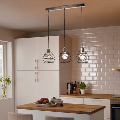 Modern kitchen with white BRUNSTA pendant lamps above wooden island, holding fruit bowl. Light, geometric design complements clean, minimalist decor.