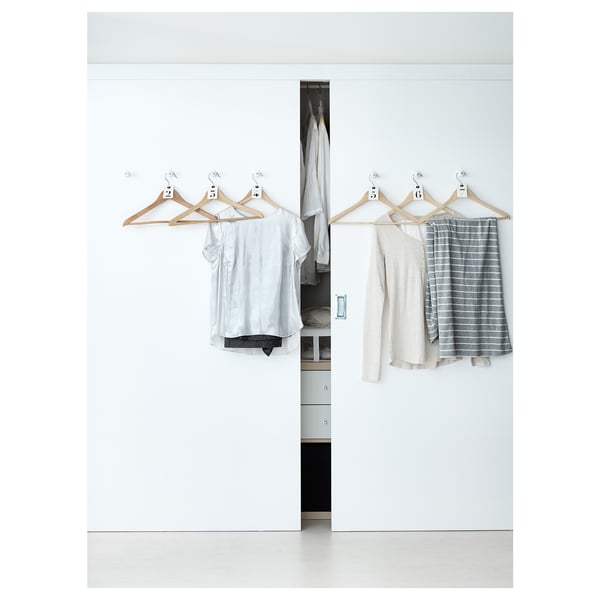 Minimalist closet with BUMERANG hangers, solid wood & chrome, preventing clothes slide.