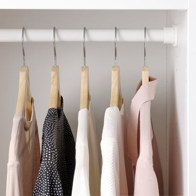Closet with 6 items on wooden hangers.