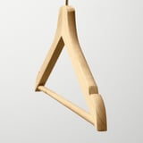 A high-quality wooden hanger, gleaming with polished finish, designed to keep clothes neat and organized.