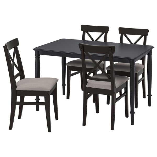 Black wooden chairs with grey cushions around black square dining table.