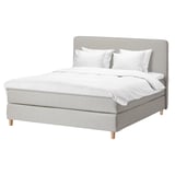 Modern gray fabric bed with white linens, wooden legs, headboard.