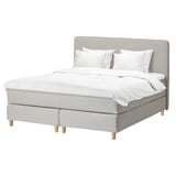 DUNVIK bed. Light grey upholstery, wooden legs, headboard, white bedding.