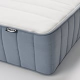 Close-up of a white ikea mattress showcasing its firm, textured surface, and edge stitching for durability.