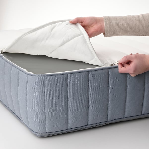 A person is opening a gray foam mattress.