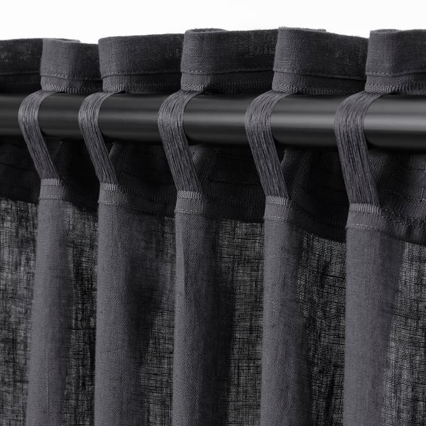 Black curtains with looped rod pockets, designed to hang and provide privacy while allowing light through.
