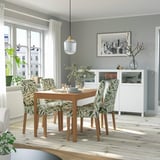 Modern dining set with extendable table, green chairs, white sideboard, and window view.