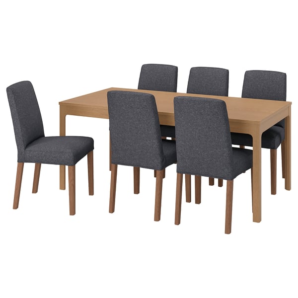 A grey, extendable dining set. It includes a light wood table and six matching chairs.