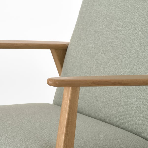 Close-up of stylish retro armchair with solid wood arms and cushy seat.