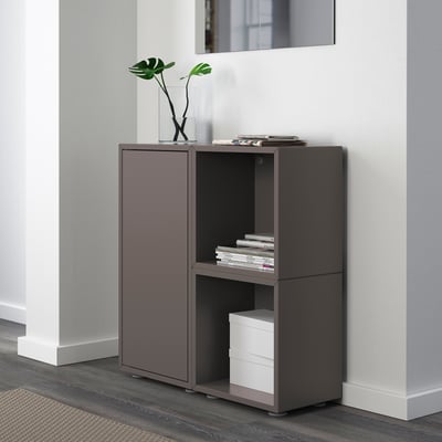 Modern storage unit with compartments, books, plants, and filing cabinet.