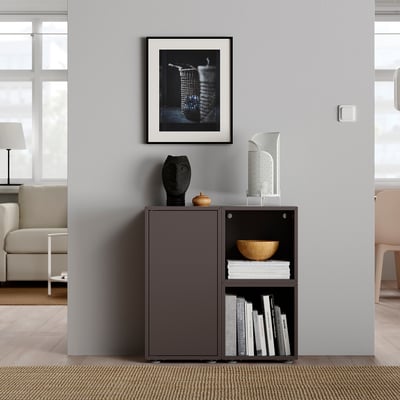 Modern living room with gray EKET storage, books, and abstract art.