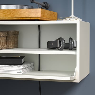 White wall-mounted shelf unit with a record player on top, a vr headset and controllers on the middle shelf, and books on the bottom shelf.