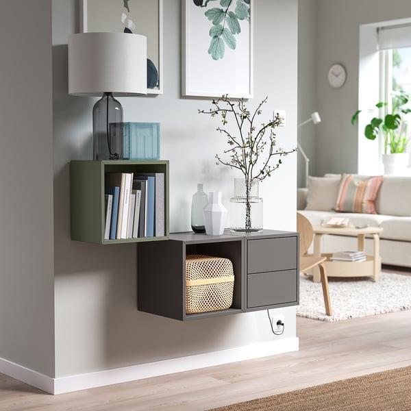 Modern wall-mounted storage: EKET. Greenish-grey compartments, books, vases. Small, sleek, organized.