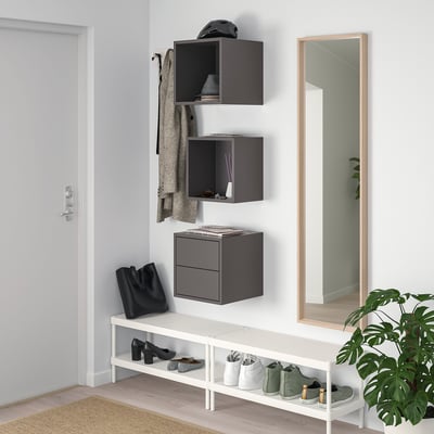Gray EKET wall cabinets, shoe rack, large mirror, plant, and woven mat in entryway.