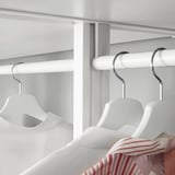White closet with hanging rods and hangers. Drawers and shelves adjust to fit clothing.