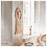 ENERGISKOG wall decor, a round mirror with beige macramé. It hangs on a white wall near a window, giving a warm, cozy look.