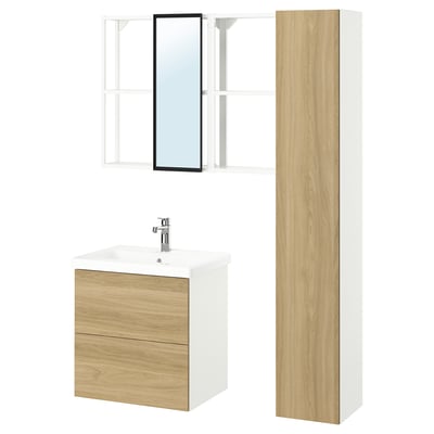 A modern wooden bathroom cabinet with a white sink, a tall storage cabinet, and a wall-mounted mirror. The units have a light wood finish.