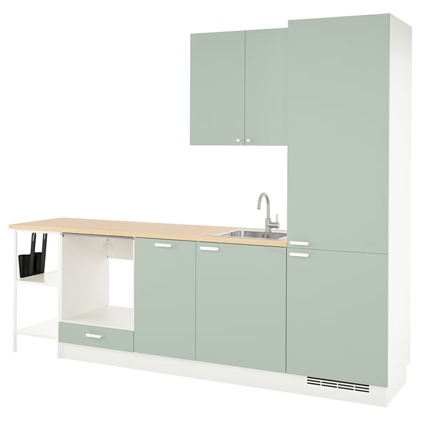 Modern kitchen setup in pale grey-green with light countertop, built-in sink, storage cabinets, and open shelves.