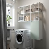 Grey-green ENHET storage unit above washing machine in bathroom, holding towels & laundry.