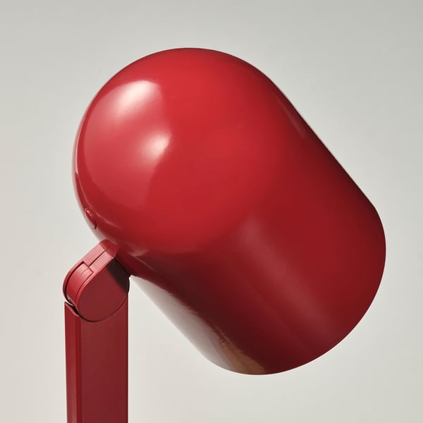 Red modern desk lamp with smooth, rounded shade. Slim, clean design with glimmering finish. Adjustable for perfect lighting.