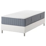 IKEA bed with grey-blue mattress on white base. Rectangular, minimalist design.