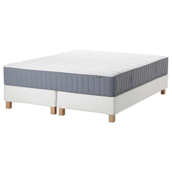 IKEA mattress in white & blue, rectangular, on white base with wooden legs.