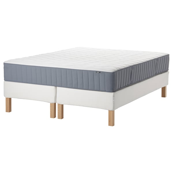 Modern white bed frame with grey mattress, wooden legs, and quilted top.