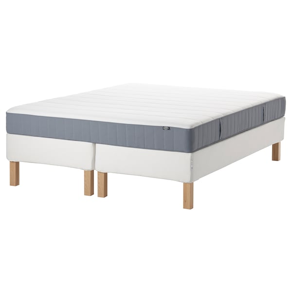 This image shows an ESPEVÄR/VESTERÖY bed in white with a gray mattress. The bed has wooden legs and a quilted design.