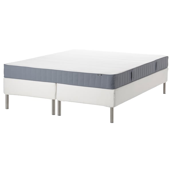 A white and gray roll-packed bonnell spring mattress on a white bed base with stainless steel legs, offering stable support and even comfort.