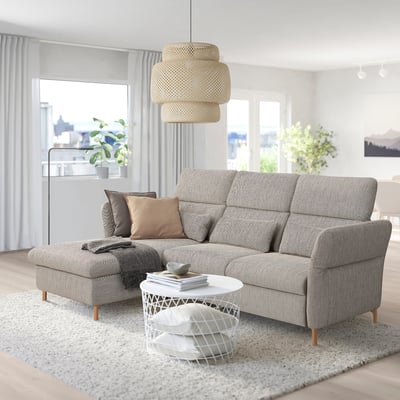 Grey FAMMARP sofa with adjustable footstool, & pillows. White coffee table, pendant light, & large windows with curtains.