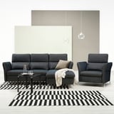Modern living room with dark gray FAMMARP sofa and chair, black-and-white striped rug, and globe pendant lights.