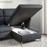 Sofa with opened storage compartment, showing folded blanket inside. Adjustable headrest and armrests.