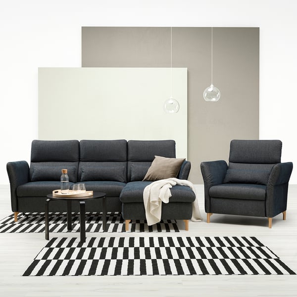 Modern living room with gray FAMMARP sofa and chair, black and white striped rug, wooden coffee table, and hanging lamps.