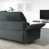 Modern living room with black FAMMARP sofa; comfortable, adjustable, icy grey rug, tv stand, and decorative art.