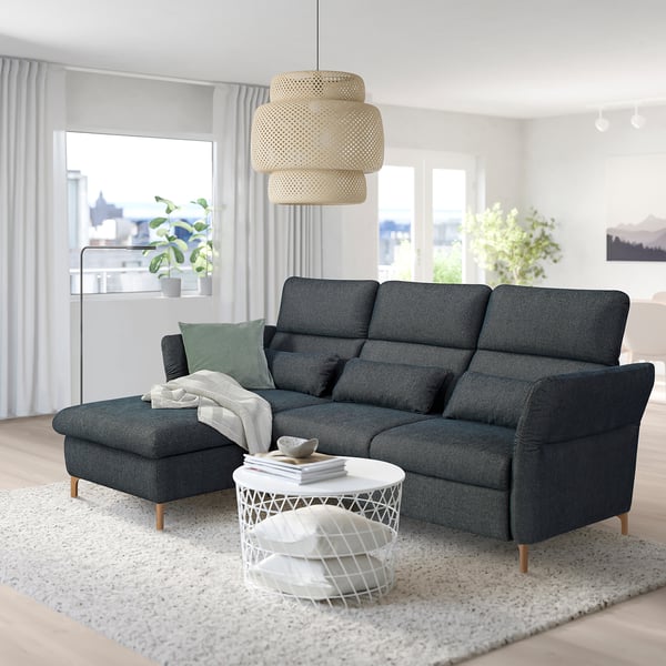 Gray FAMMARP sectional sofa, large, modern design, fabric cover. Central coffee table, stylish pendant light. Large windows with city view.