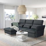 Gray FAMMARP sectional sofa, large, modern design, fabric cover. Central coffee table, stylish pendant light. Large windows with city view.