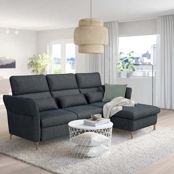 Modern living room with dark grey FAMMARP 3-seat sofa, white coffee table, and large window. Sofa adjustable headrests and armrests.