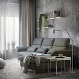 Modern living room with gray FAMMARP sofa, white side table, hanging plants, and large window with sheer curtains.