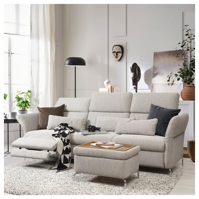 Modern living room with gray sectional sofa, pillows, rug, and plants.