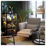 Living room with gray FAMMARP sofa, glass coffee table, black display cabinet with decorative items, large palm plant, and wicker pendant lamp.