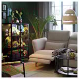 Modern living room with FAMMARP beige fabric sofa, glass coffee table, green walls, large window, and decorative shelves with vases and plants.