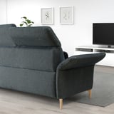 A FAMMARP sofa in grey with a textured pattern, medium size, and wooden legs. It has adjustable cushions and sits below a tv and wall art.