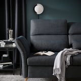 Grey FAMMARP sofa, lamp, books, coffee maker, teal wall.