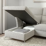 Modern sofa with adjustable headrest, revealing hidden storage compartment. Ideal for space-saving and comfort.